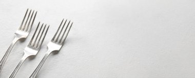 Açık arkaplanda gümüş çatallar ve metin için boşluk