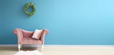 Odada ökseotu çelengi olan mavi duvarın yanında şık bir dinlenme odası.