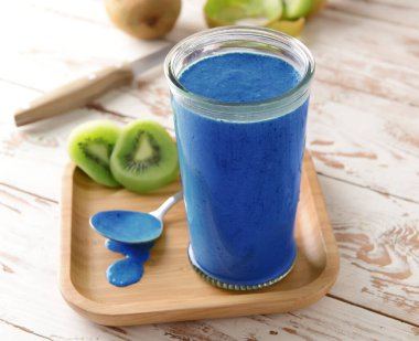 Masada bir bardak sağlıklı mavi spirulina kokteyli.