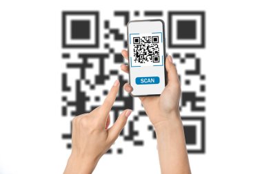 Akıllı telefonlu bir kadının elleri beyaz arkaplanda QR kodunu tarıyor.