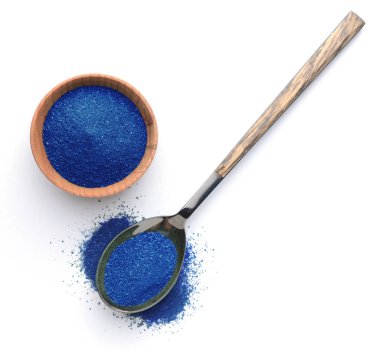 Bowl and spoon with blue spirulina powder on white background
