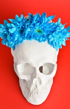 Kırmızı arka planda çiçekli insan kafatası