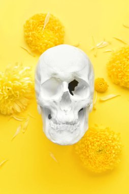 Sarı arka planda çiçekli insan kafatası