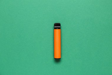 Yeşil arka planda tek kullanımlık elektronik sigara.