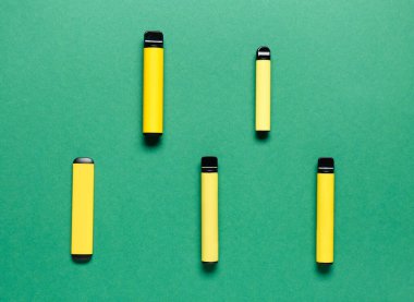 Disposable electronic cigarettes on green background