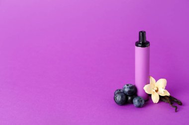 Tek kullanımlık elektronik sigara, mor arka planda yabanmersini ve vanilya çiçeği.