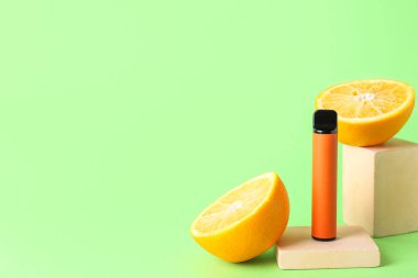 Tek kullanımlık elektronik sigara ve yeşil arka planda turuncu.