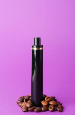 Tek kullanımlık elektronik sigara ve mor arka planda kahve çekirdekleri.