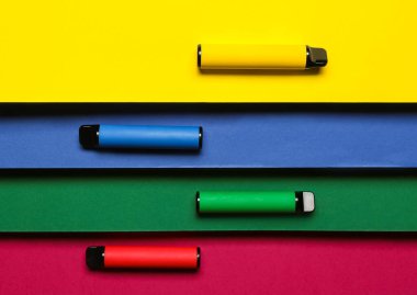 Sarı arka planda tek kullanımlık elektronik sigaralar.