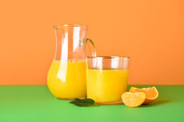 Arka planda taze mandalina suyu ve sürahi.