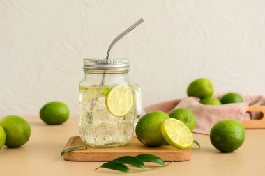 Masada soğuk su ve taze limonlu Mason kavanozu.