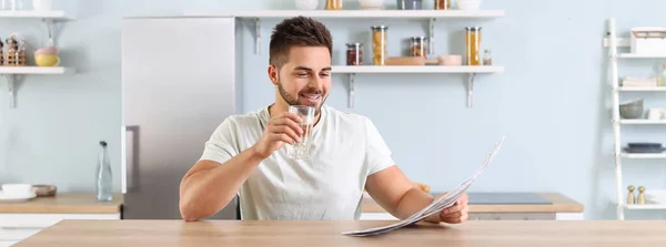 Handsome Young Man Reading Newspaper While Drinking Water Kitchen — Stock Photo, Image