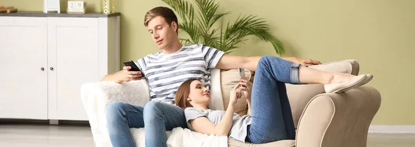 Young Couple Mobile Phones Relaxing Sofa Home — Zdjęcie stockowe