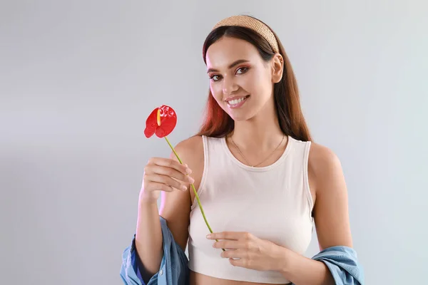 Mujer Sonriente Sosteniendo Flor Anturio Sobre Fondo Claro — Foto de Stock