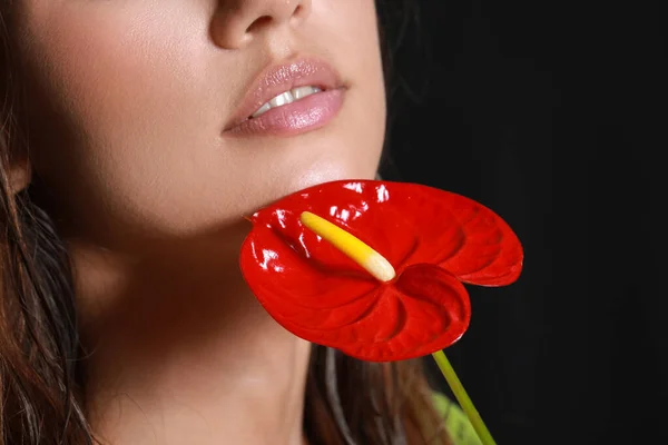 Młoda Kobieta Kwiatem Anthurium Ciemnym Tle Zbliżenie — Zdjęcie stockowe