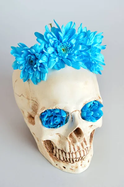 Gri arka planda çiçekli insan kafatası