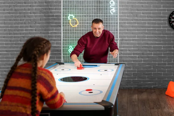 Bir adam ve küçük kızı içeride hokey oynuyorlar.