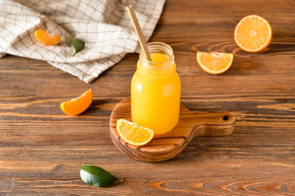 Ahşap arka planda bir şişe taze mandalina suyu.