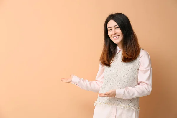 Inviting Young Asian Woman Showing Something Beige Background — Foto Stock