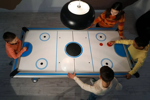 Küçük çocuklar içeride hokey oynuyorlar.