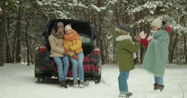 Ormanda, arabanın yanında mutlu bir aile.