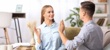 Evde işaret dili kullanan genç sağır ve dilsiz bir çift.