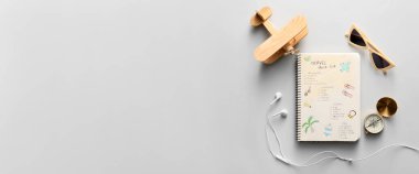 Seyahat listeli defter, oyuncak uçak, pusula, güneş gözlüğü ve kulaklık açık arkaplan ve metin için boşluk