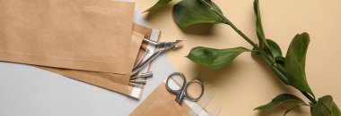 Manikür aletleri ve yeşil arkaplanlı kağıt torbalar.