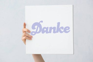 Açık arkaplanda DANKE (Almanca Teşekkür) sözcüğüyle el ele tutuşma belgesi