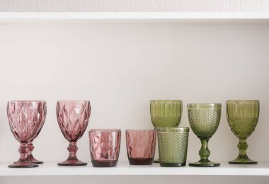 Beyaz rafta farklı şık gözlükler.