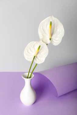 Masada güzel anthurium çiçekleri olan vazo.