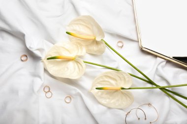 Kumaş zemin üzerinde güzel anthurium çiçekleri ve aksesuarlar