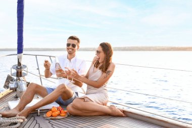 Happy young couple resting on yacht