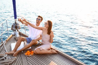 Happy young couple resting on yacht