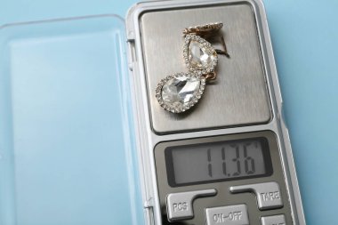 Mavi arka planda küpeli mücevher pulları, yakın plan.