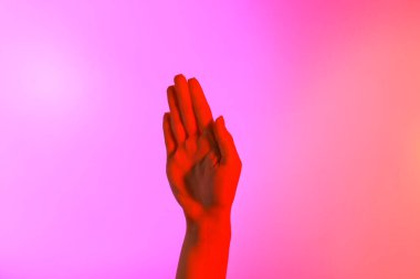 Pembe arka planda tonlanmış kadın eli