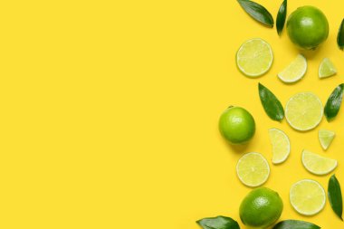 Sarı arka planda olgun kireç ve yapraklı kompozisyon