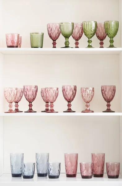 Different empty glasses on shelf unit