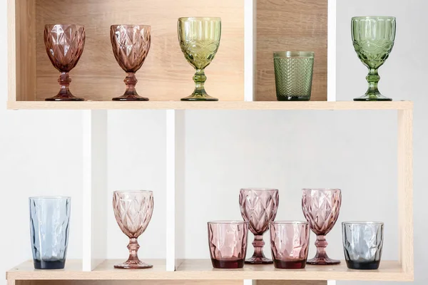 Ahşap raf ünitesinde farklı boş bardaklar.