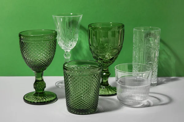 Stylish Empty Glasses Green Background — Stock Photo, Image