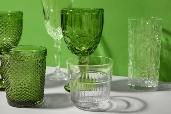 Stylish Empty Glasses Green Background — Stock Photo, Image