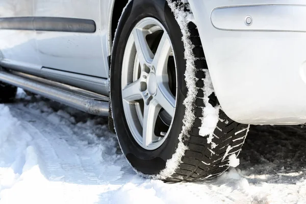 Karlı kış gününde araba tekerleği, yakın plan.