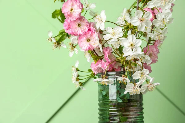 Yeşil duvara yakın, çiçekli bir vazo.