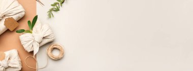 Kumaş ve çiçeklere sarılı hediye kutuları hafif arkaplanda metin için boşluk ile