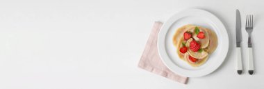 Plate with sweet dumplings and strawberry on white background with space for text
