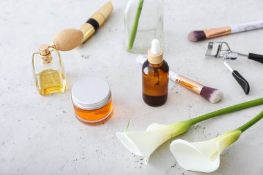 Hafif arkaplanda kozmetik ürünler, araçlar ve kalla zambakları