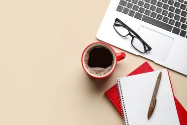 Bir fincan kahve, defterler, gözlükler ve dizüstü bilgisayarlar.