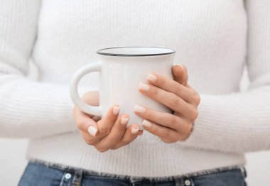 Woman holding ceramic cup, closeup