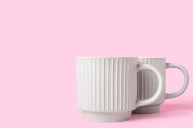 Pembe arka planda iki seramik bardak