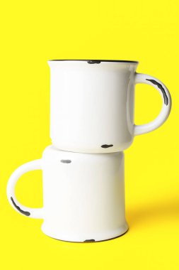 Sarı arkaplanda seramik bardaklar